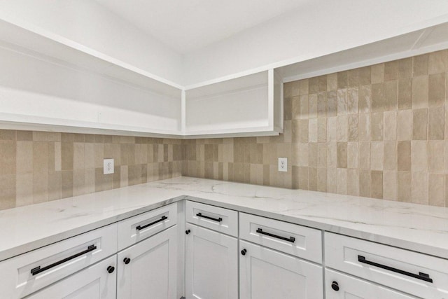1111 Spearson Ln, Austin, TX 78745 - kitchen with white cabinets, tasteful backsplash, and light stone countertops
