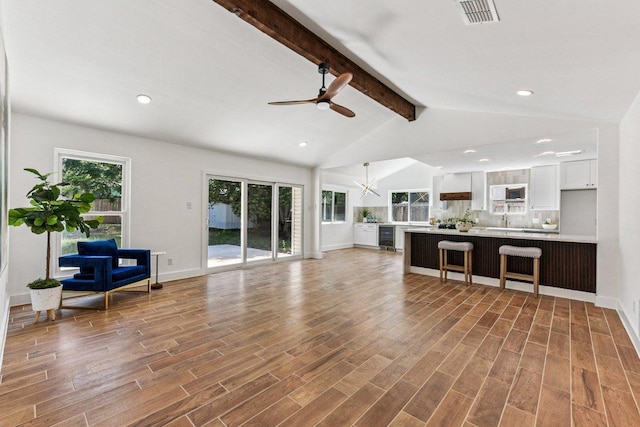 1111 Spearson Ln, Austin, TX 78745 - unfurnished living room with ceiling fan, wood finished floors, a chandelier, beverage cooler, and recessed lighting