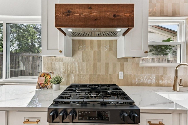 1111 Spearson Ln, Austin, TX 78745 - kitchen with custom exhaust hood, gas range oven, plenty of natural light, and tasteful backsplash