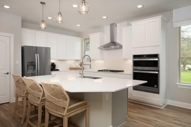 217 Peach Orchard Ln, Georgetown, TX 78628 - kitchen with stainless steel appliances, wall chimney range hood, a sink, white cabinetry, and recessed lighting