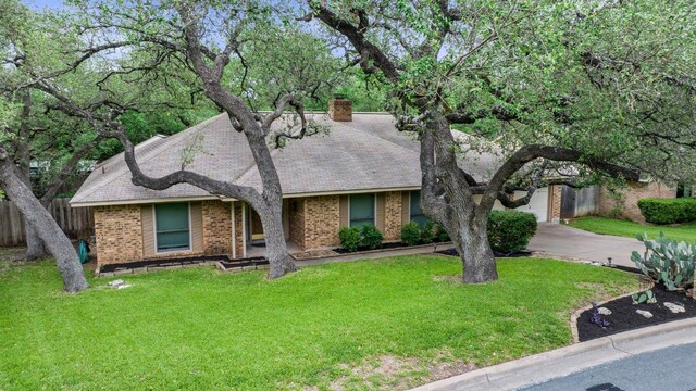 11311 Alhambra Dr, Austin, TX 78759 - view of front of house with brick siding, driveway, a chimney, and a shingled roof