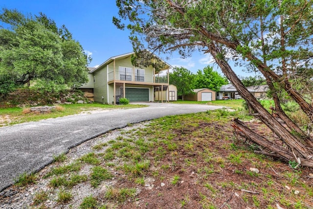 1219 Canyon Trce, Canyon Lake, TX 78133 - view of front of house with a storage shed, an attached garage, and asphalt driveway