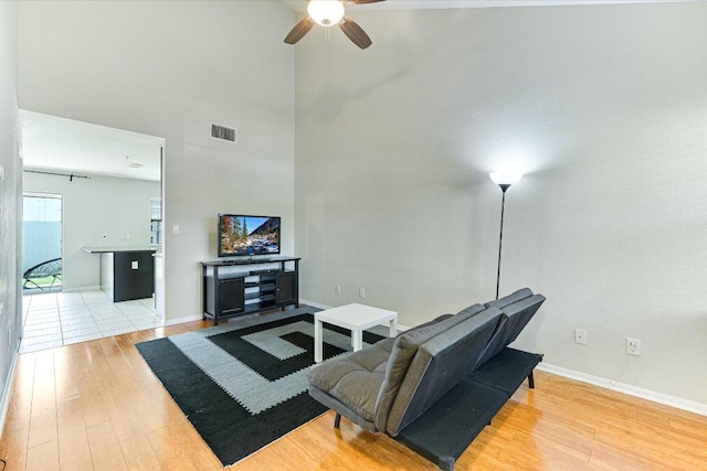 401 Buttercup Creek Blvd Unit 505, Cedar Park, TX 78613 - living room featuring light wood-type flooring, a ceiling fan, baseboards, and a high ceiling