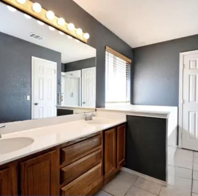 507 Dusty Leather Ct, Pflugerville, TX 78660 - bathroom featuring double vanity, a shower stall, and tile patterned floors