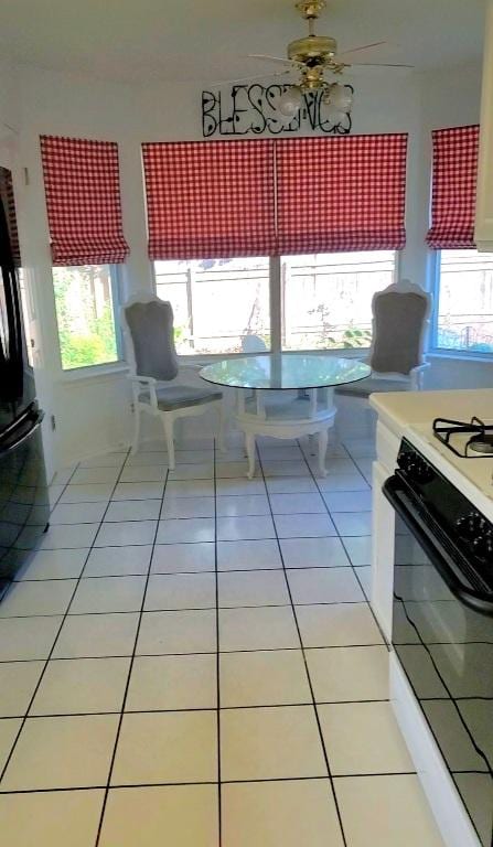 507 Dusty Leather Ct, Pflugerville, TX 78660 - kitchen with freestanding refrigerator, range with gas cooktop, light tile patterned floors, light countertops, and ceiling fan