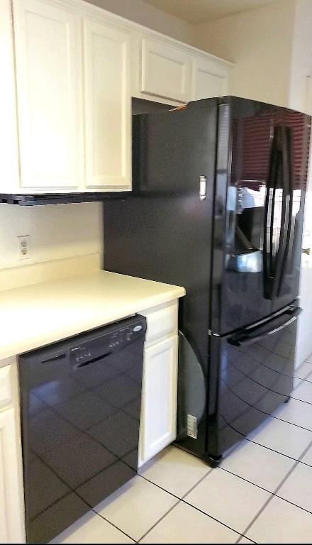 507 Dusty Leather Ct, Pflugerville, TX 78660 - kitchen with black appliances, light tile patterned floors, white cabinets, and light countertops