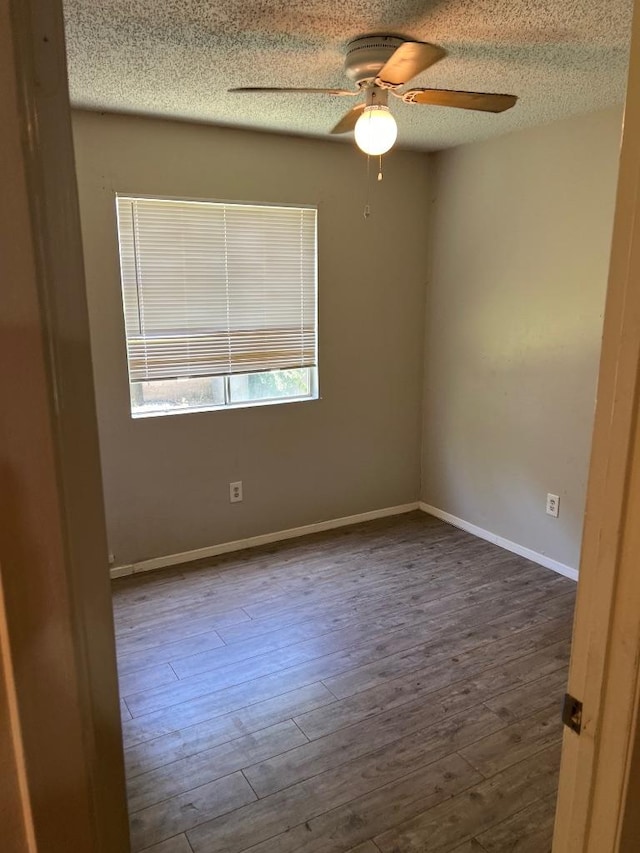 1010 Wayne Dr, Round Rock, TX 78664 - spare room featuring ceiling fan, dark wood-style floors, a textured ceiling, and baseboards