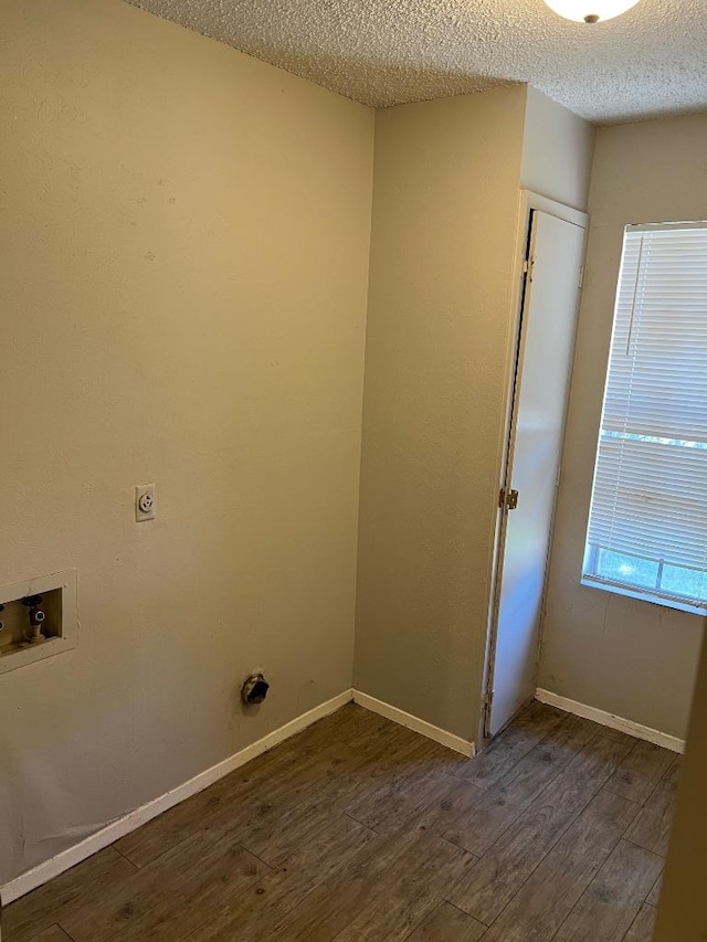 1010 Wayne Dr, Round Rock, TX 78664 - washroom with a textured ceiling, hookup for an electric dryer, dark wood finished floors, hookup for a washing machine, and baseboards