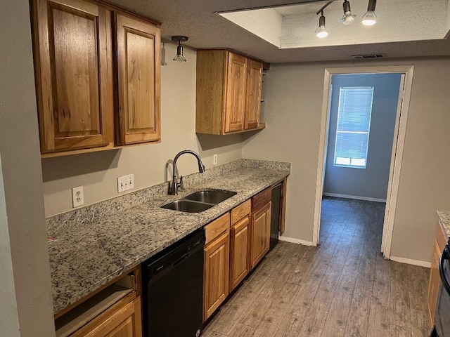 1010 Wayne Dr, Round Rock, TX 78664 - kitchen with dishwasher, a sink, light wood finished floors, track lighting, and brown cabinetry