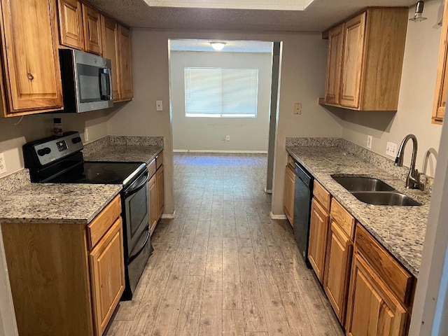 1010 Wayne Dr, Round Rock, TX 78664 - kitchen with stainless steel microwave, black electric range oven, a sink, dishwashing machine, and light wood-type flooring