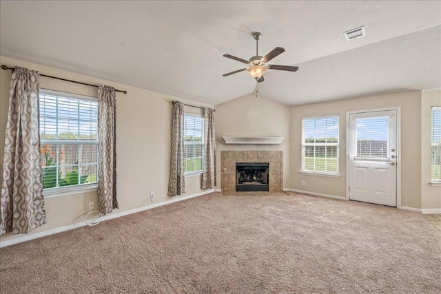 14513 Martial Eagle Dr, Elgin, TX 78621 - unfurnished living room featuring ceiling fan, carpet floors, plenty of natural light, vaulted ceiling, and a tile fireplace