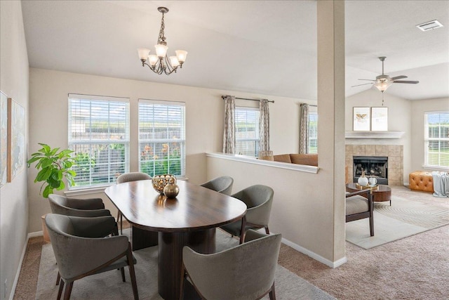 14513 Martial Eagle Dr, Elgin, TX 78621 - dining space with carpet floors, vaulted ceiling, a chandelier, a ceiling fan, and a tiled fireplace