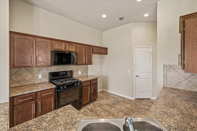 14513 Martial Eagle Dr, Elgin, TX 78621 - kitchen with black gas range, decorative backsplash, light stone counters, and recessed lighting