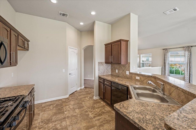 14513 Martial Eagle Dr, Elgin, TX 78621 - kitchen with black appliances, arched walkways, backsplash, recessed lighting, and dark stone countertops