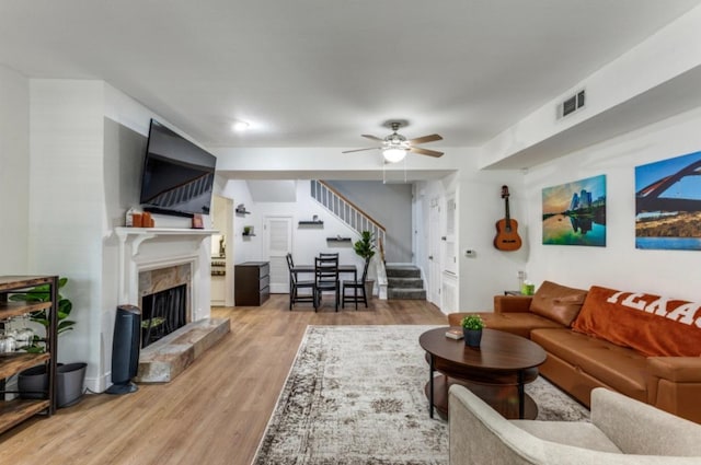 2529 Rio Grande St Unit 51, Austin, TX 78705 - living room with stairway, light wood-style floors, a fireplace, and ceiling fan
