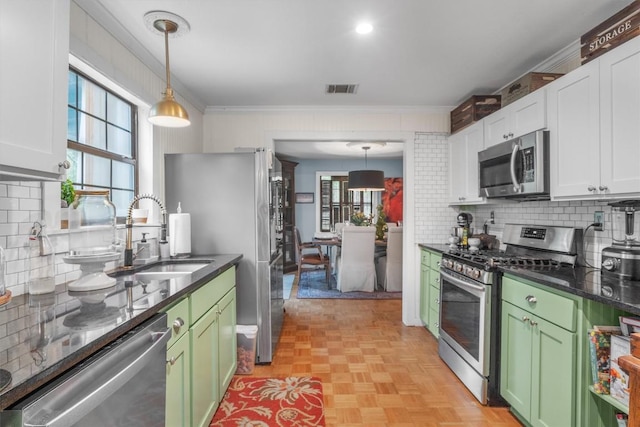 220 River Rapids Rd, Wimberley, TX 78676 - kitchen with stainless steel appliances, green cabinetry, a sink, backsplash, and ornamental molding
