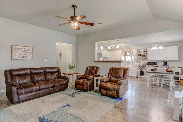 700 Indian Blanket St, Lockhart, TX 78644 - living room featuring light wood-type flooring, a ceiling fan, and a chandelier