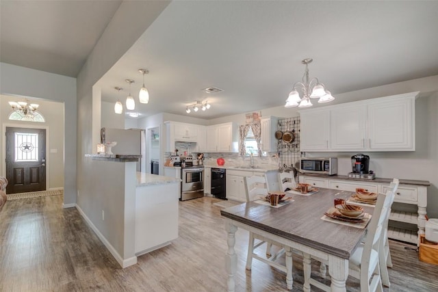 700 Indian Blanket St, Lockhart, TX 78644 - kitchen featuring a chandelier, stainless steel appliances, tasteful backsplash, and white cabinetry