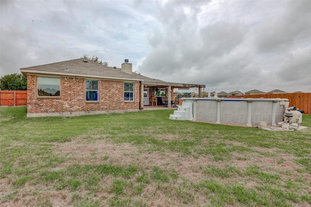 700 Indian Blanket St, Lockhart, TX 78644 - rear view of house with a fenced backyard, a chimney, and brick siding