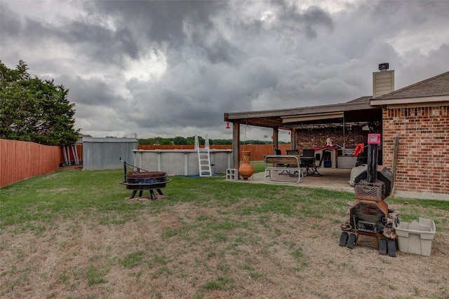 700 Indian Blanket St, Lockhart, TX 78644 - fenced backyard with an outdoor fire pit, a patio area, and an outdoor pool
