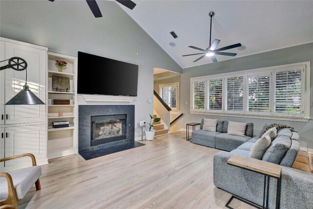 4812 Mantle Dr, Austin, TX 78746 - living room featuring a ceiling fan, light wood-style flooring, stairs, a high end fireplace, and high vaulted ceiling