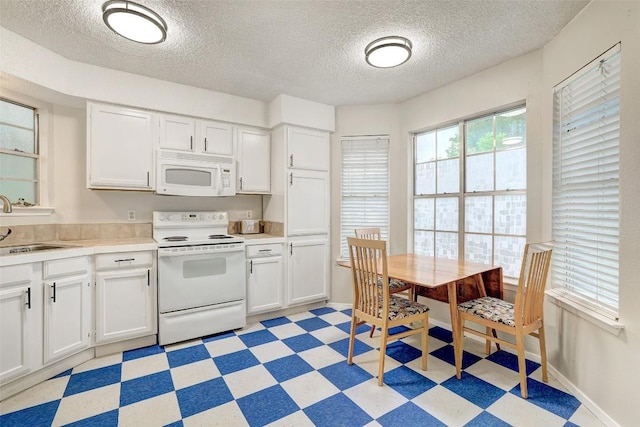 2008 Kenneth Ave Unit B, Austin, TX 78741 - kitchen featuring white appliances, light floors, a textured ceiling, white cabinetry, and a sink