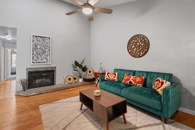 203 E 31st St Unit 304, Austin, TX 78705 - living area with a ceiling fan, wood finished floors, a fireplace with raised hearth, a high ceiling, and baseboards