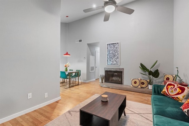 203 E 31st St Unit 304, Austin, TX 78705 - living area featuring high vaulted ceiling, wood finished floors, ceiling fan, baseboards, and a fireplace with raised hearth