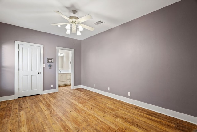 412 Haney Trce, Horseshoe Bay, TX 78657 - unfurnished bedroom featuring baseboards, light wood-style flooring, ensuite bathroom, and ceiling fan