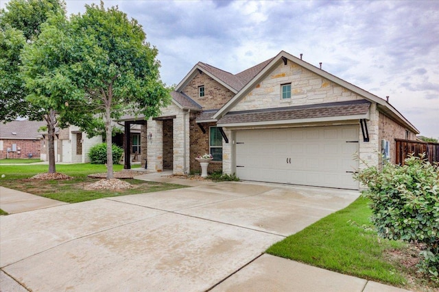 216 Allegrini St, Leander, TX 78641 - view of front of property with stone siding, driveway, a shingled roof, and a front lawn