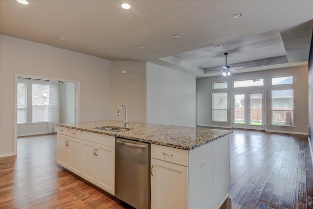 216 Allegrini St, Leander, TX 78641 - kitchen with stainless steel dishwasher, wood finished floors, healthy amount of natural light, light stone counters, and recessed lighting
