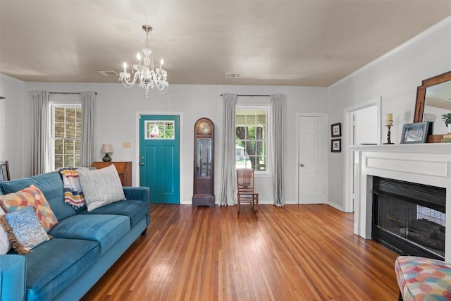 1922 W Lake Dr, Taylor, TX 76574 - living area featuring wood finished floors, a chandelier, healthy amount of natural light, and a fireplace