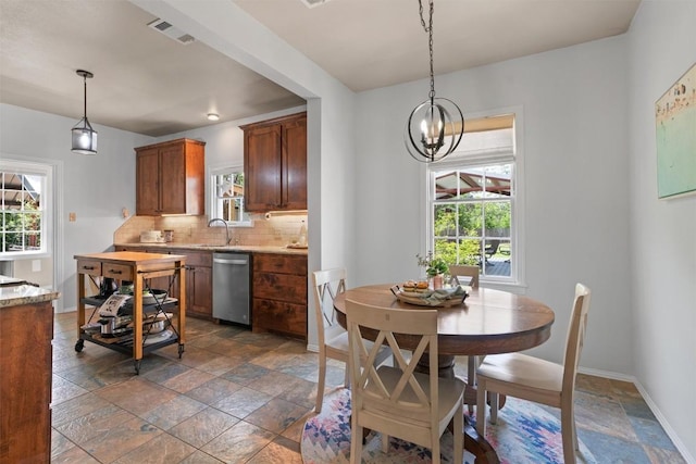 1922 W Lake Dr, Taylor, TX 76574 - dining space with stone tile floors and a chandelier