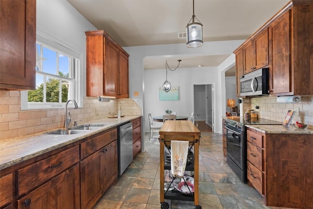 1922 W Lake Dr, Taylor, TX 76574 - kitchen with stainless steel appliances, backsplash, light stone counters, pendant lighting, and stone finish floors