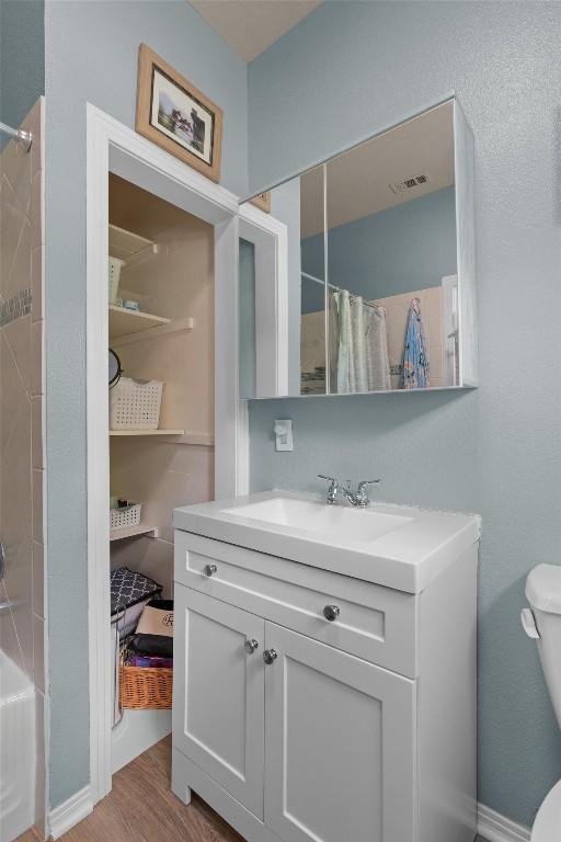 1922 W Lake Dr, Taylor, TX 76574 - bathroom with vanity, curtained shower, and wood finished floors