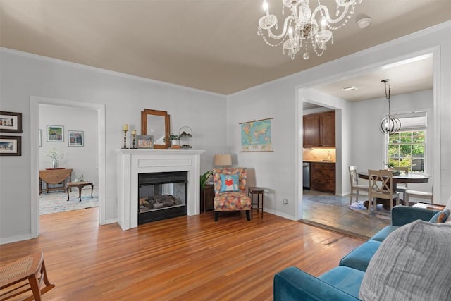 1922 W Lake Dr, Taylor, TX 76574 - living area featuring light wood finished floors, ornamental molding, a glass covered fireplace, and a chandelier