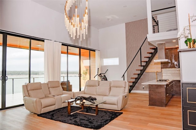 1800 Buffalo Gap Rd, Austin, TX 78734 - living area featuring a towering ceiling, stairs, wood finished floors, a water view, and a chandelier