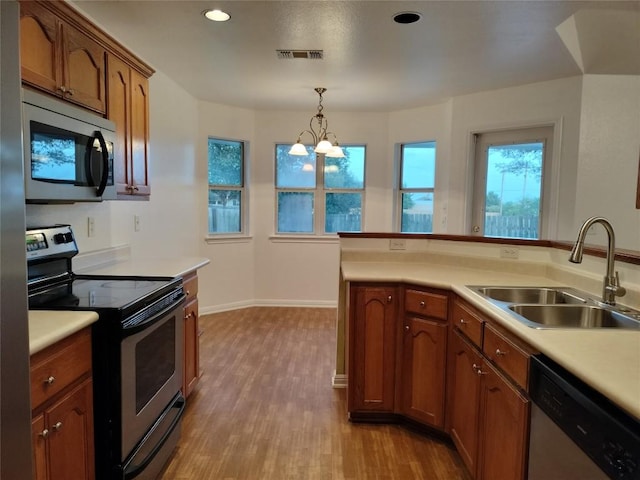 1111 Blazewood Dr, New Braunfels, TX 78130 - kitchen featuring appliances with stainless steel finishes, a sink, light wood-style floors, light countertops, and a chandelier