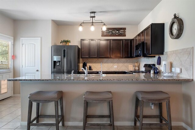 1407 Brashear Ct, Cedar Park, TX 78613 - kitchen with stainless steel fridge, stove, stone countertops, and black microwave