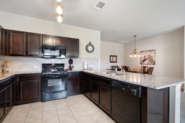 1407 Brashear Ct, Cedar Park, TX 78613 - kitchen featuring black appliances, a peninsula, backsplash, dark brown cabinetry, and light stone countertops
