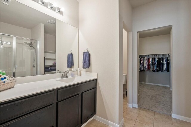1407 Brashear Ct, Cedar Park, TX 78613 - bathroom with a spacious closet, a shower stall, tile patterned flooring, and vanity
