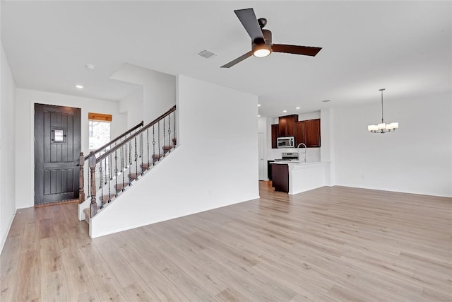 13308 Nancy Reagan St, Manor, TX 78653 - unfurnished living room featuring a chandelier, light wood-style flooring, stairway, a ceiling fan, and recessed lighting