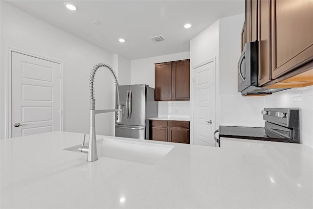 13308 Nancy Reagan St, Manor, TX 78653 - kitchen with stainless steel appliances, light countertops, recessed lighting, and tasteful backsplash