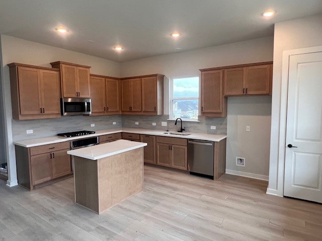 20013 Aqua Reef Dr, Austin, TX 78747 - kitchen featuring stainless steel appliances, light wood-style floors, decorative backsplash, light countertops, and a kitchen island