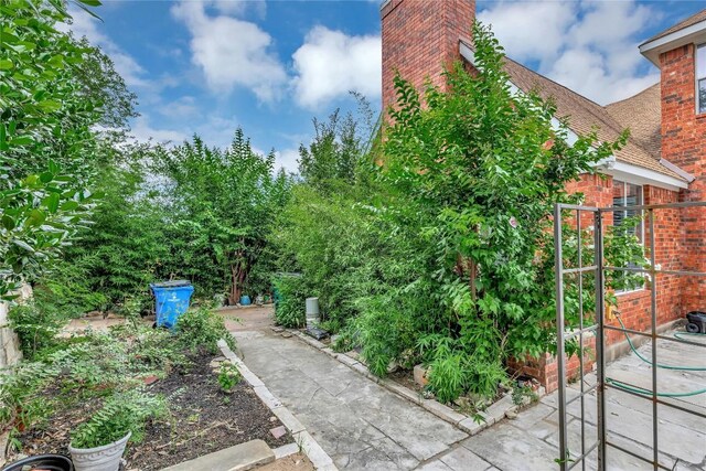 222 Vailco Ln, Austin, TX 78738 - view of side of property featuring brick siding, a chimney, and a shingled roof