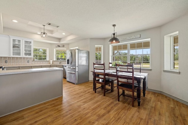 1201 County Road 229, Florence, TX 76527 - dining area featuring light wood-type flooring, a textured ceiling, recessed lighting, and a tray ceiling