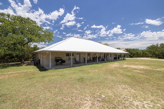 1201 County Road 229, Florence, TX 76527 - back of property with a yard, stone siding, and a patio