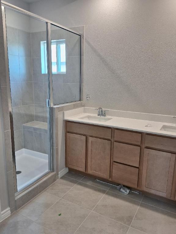 504 S Story Sts, Florence, TX 76527 - bathroom featuring a shower stall, tile patterned flooring, and double vanity