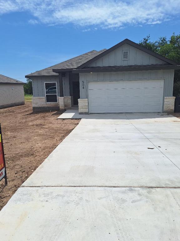 504 S Story Sts, Florence, TX 76527 - view of front of property with concrete driveway, an attached garage, board and batten siding, and roof with shingles