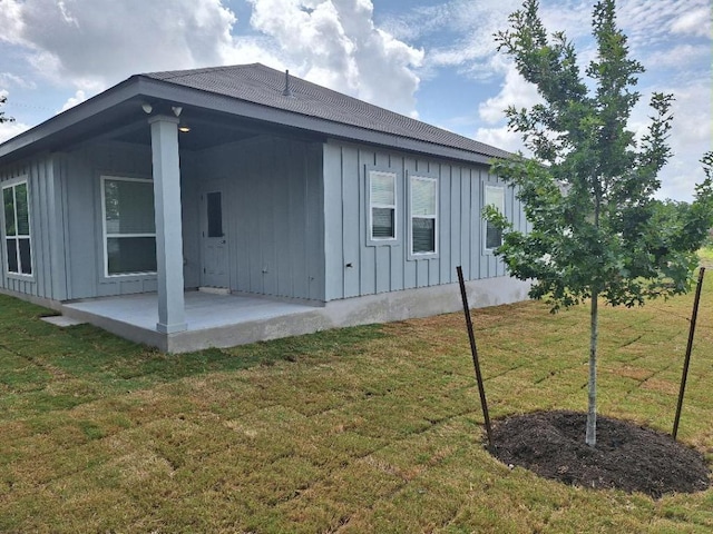 504 S Story Sts, Florence, TX 76527 - view of home's exterior featuring board and batten siding, a patio, and a lawn